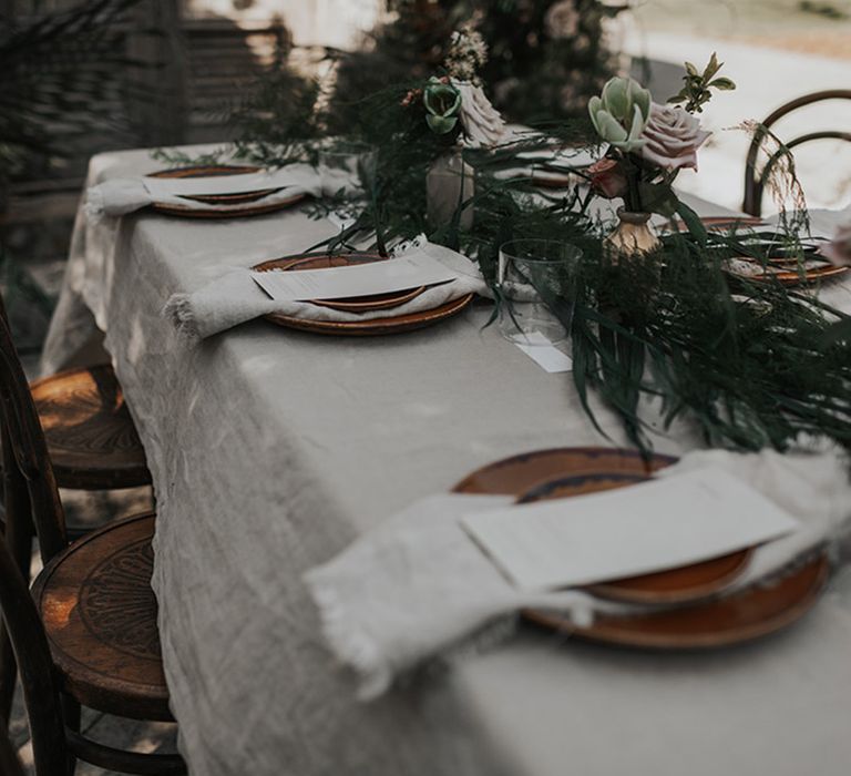 Outdoor wedding reception with linen table cloth and foliage table runner 