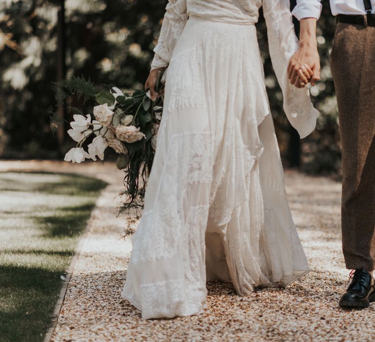 Groom in wool trousers and braces, and bride in a boho wedding dress with full skirt 