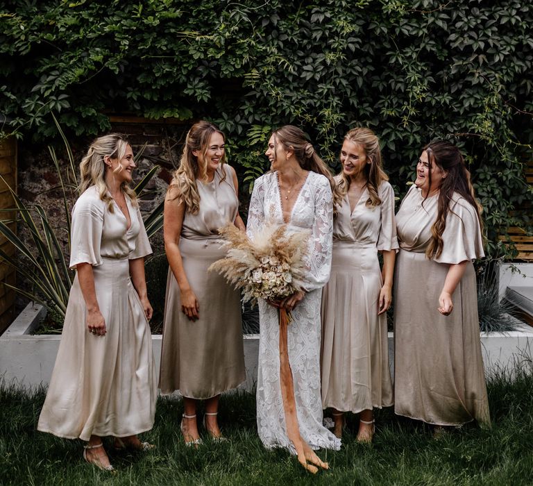 Bridesmaids in champagne coloured dresses with bride in boho wedding dress