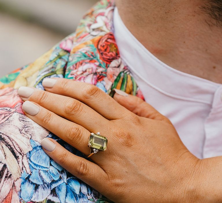 Bride with white nail polish wearing a green Peridot engagement ring 