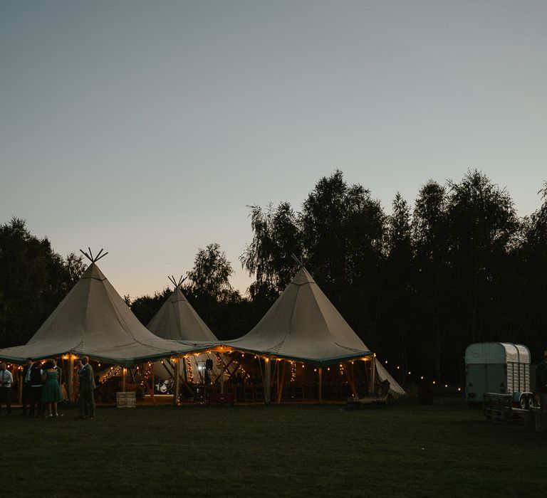 Three point tipi for wedding reception with festoon lighting during late summer wedding at Wellington Wood Norfolk