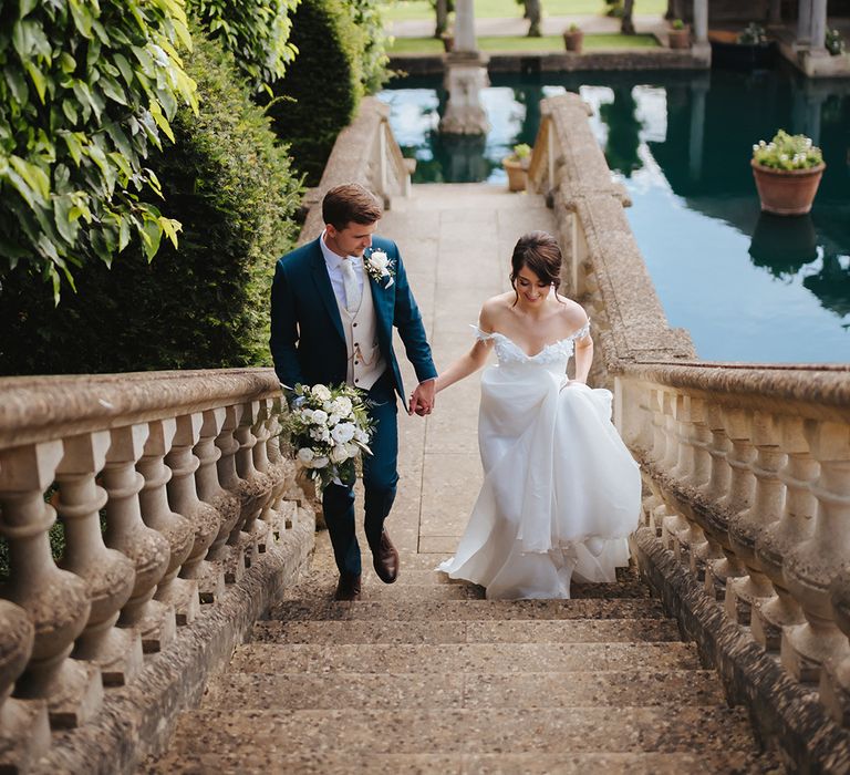 Bride & groom walk up the steps at Euridge Manor after wedding ceremony