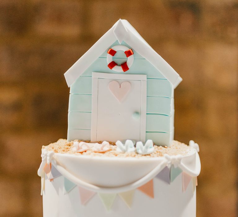 Coastal wedding at East quay Wedding venue with beach hut wedding cake topper 