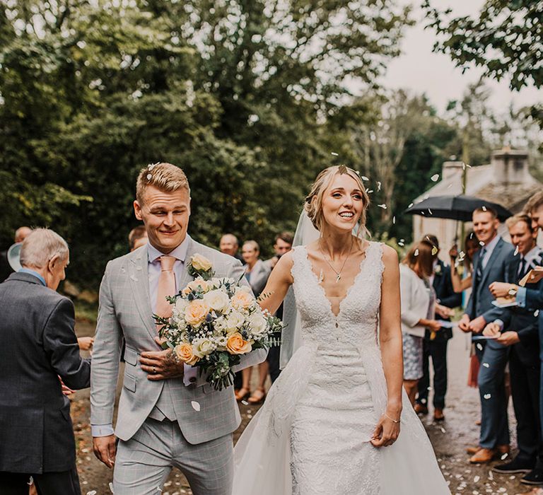 Confetti moment for bride and groom at church wedding ceremony