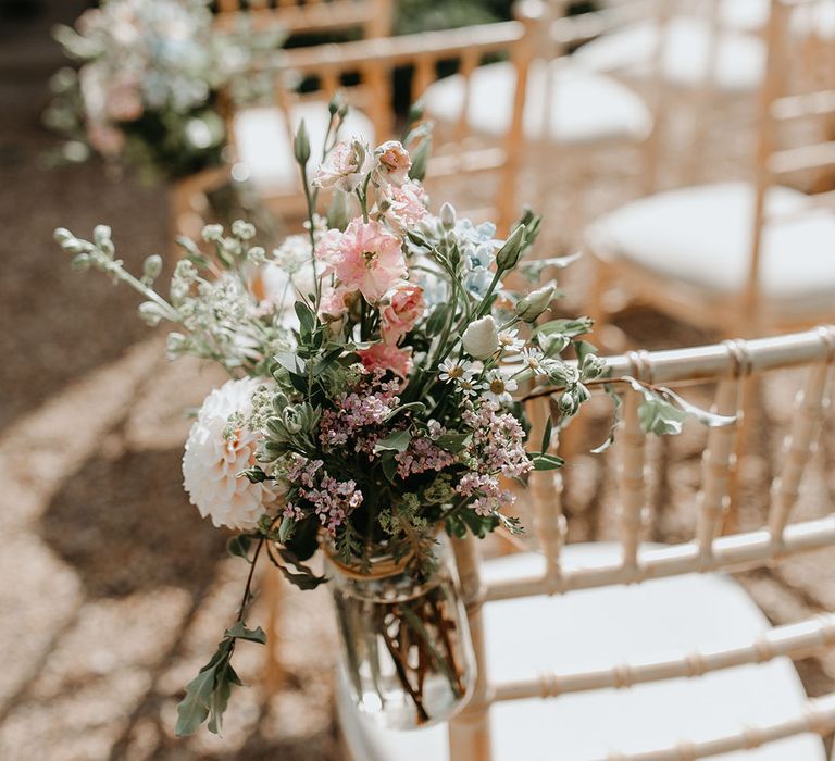 Chair complete with small glass vase filled with flowers tied to the side