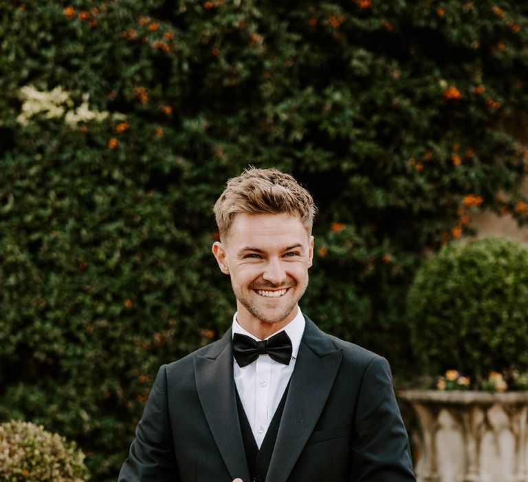 Smart groom in a three-piece tuxedo at black-tie wedding 