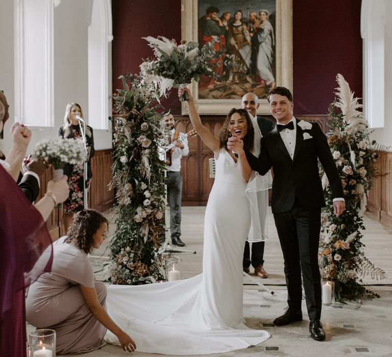 Bride & groom celebrate as they leave ceremony with one another