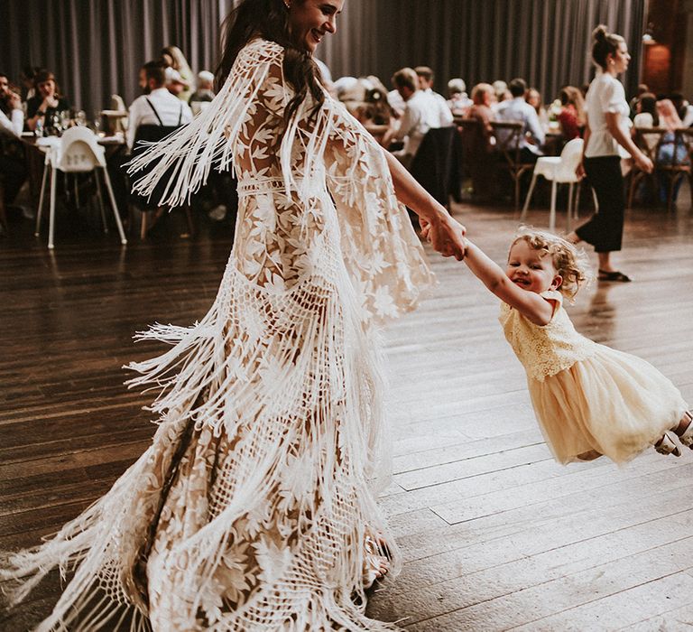 Bride dances with toddler on the day of her wedding