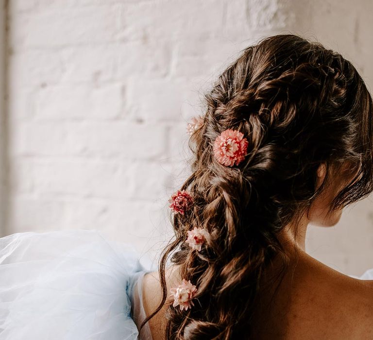 Boho braided wedding hairstyle intertwined with pink dry flower hair accessories 