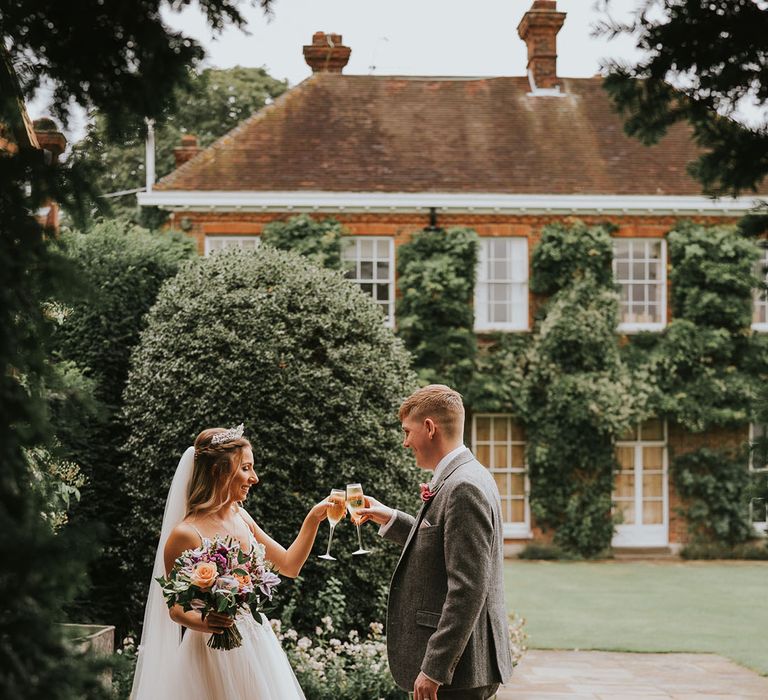 Bride and groom share a private toast at country house rustic wedding venue Micklefield Hall