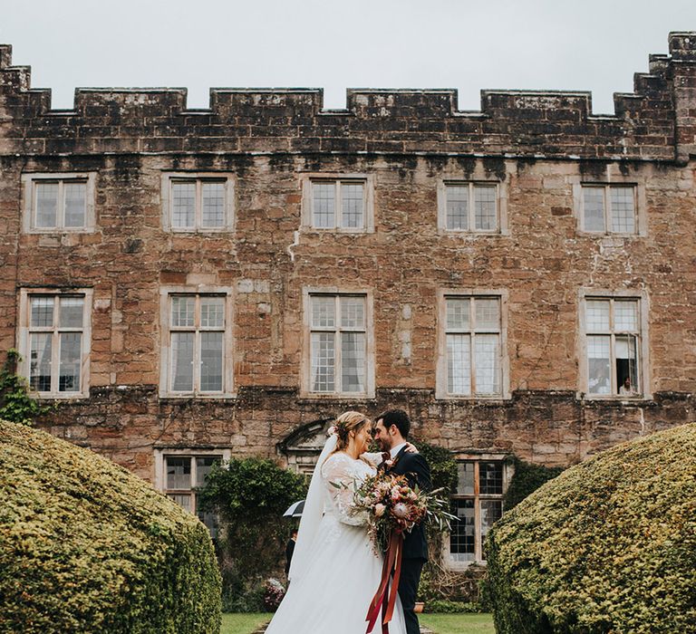 Autumn wedding at Askam hall with bride in a princess wedding dress holding a protea wedding bouquet 