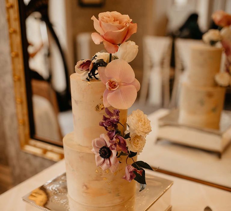 Two tiered cream wedding cake with neutral coloured rose and foliage decorations 