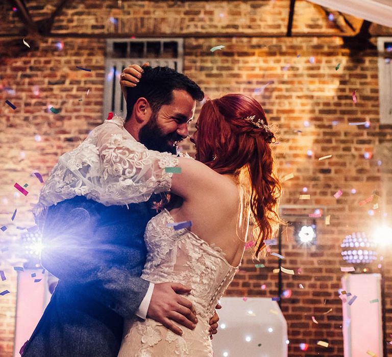 Bride and groom have a first dance as colourful confetti erupts over them 