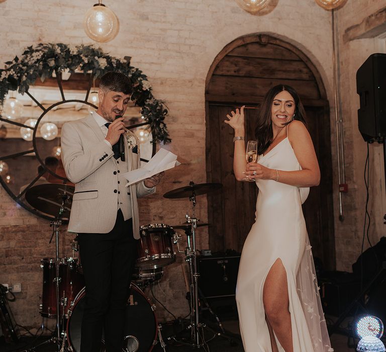 Groom reads out his speech as the bride stand with him 