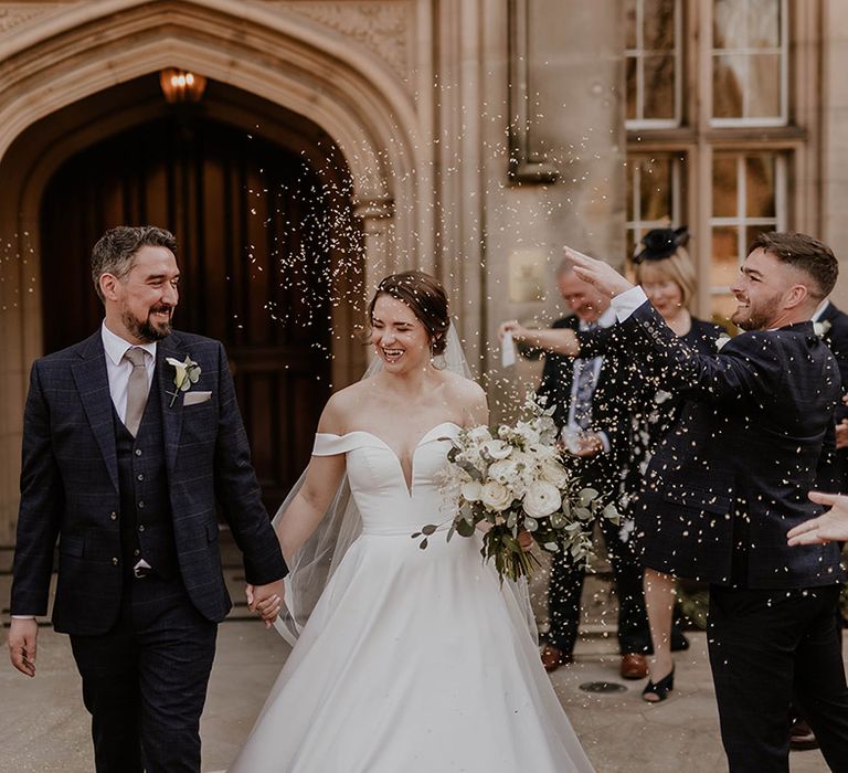 Bride and groom exit their wedding ceremony at Maften Hall to confetti 