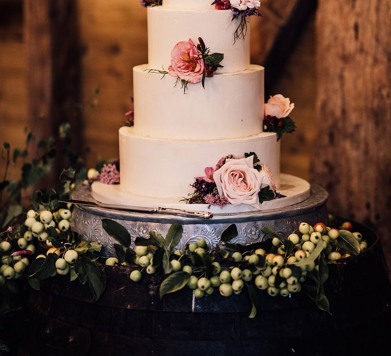 Four tier white iced wedding cake with real pink flower decoration for classic style wedding 