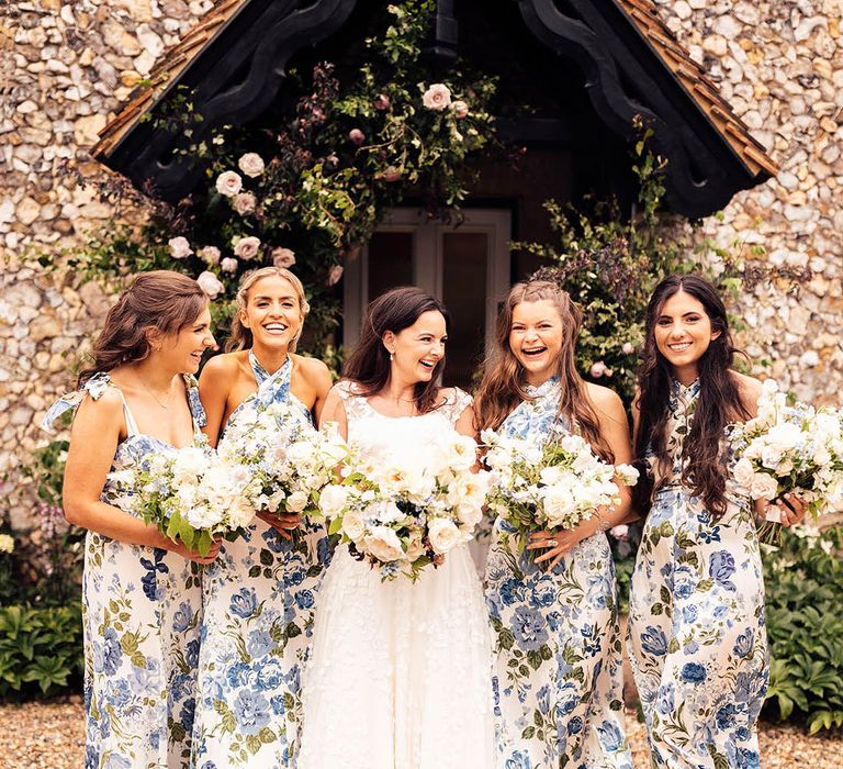 Bride in Phillipa Lepley wedding dress with the bridesmaids in blue floral dresses with white flower bouquets 