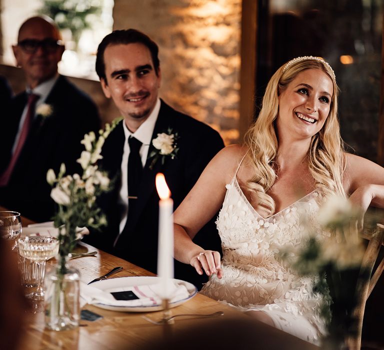 Bride and groom sit down for their wedding reception and listen to the speeches 