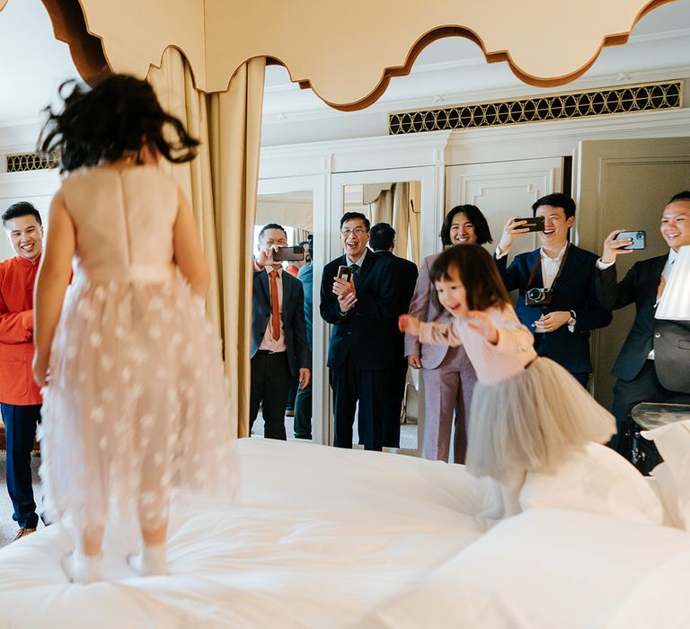 Flower girls jump on bed during wedding day at The Dorchester 