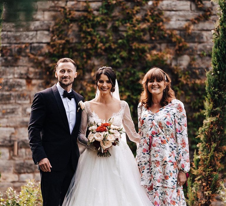 The bride and groom pose with family member on their traditional and classic wedding day 