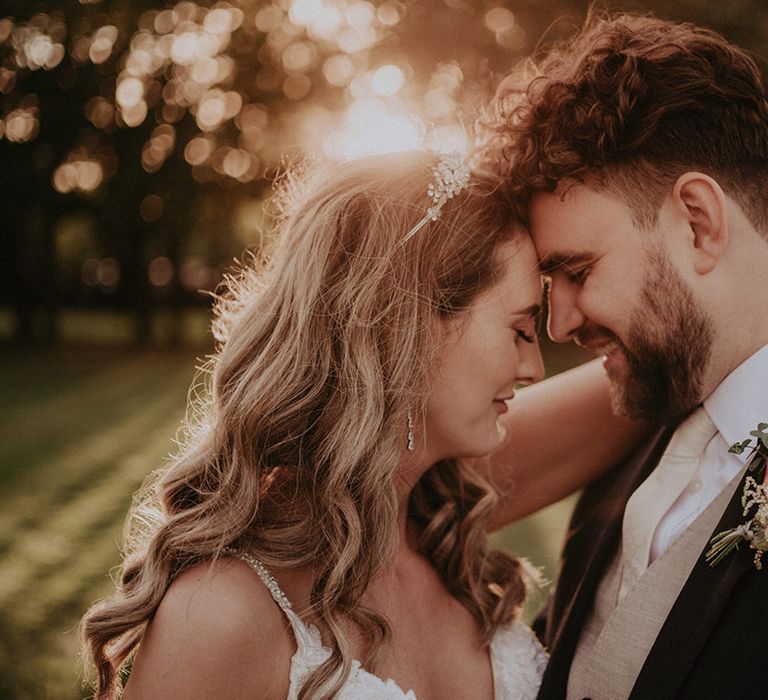 Sunset wedding photography with the bride and groom resting their foreheads against each other at their Stanlake Park wedding 