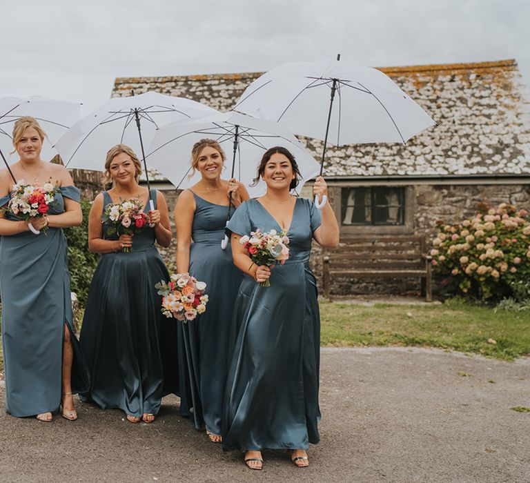 Mismatching style satin blue bridesmaid dresses worn by the bridal party for the Devon wedding 