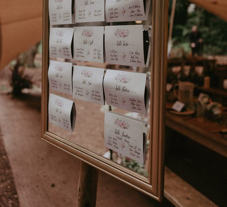 Mirror wedding seating chart signage with cards for each table 