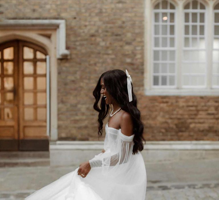 Bride in off the shoulder layered tulle wedding dress in the streets of London