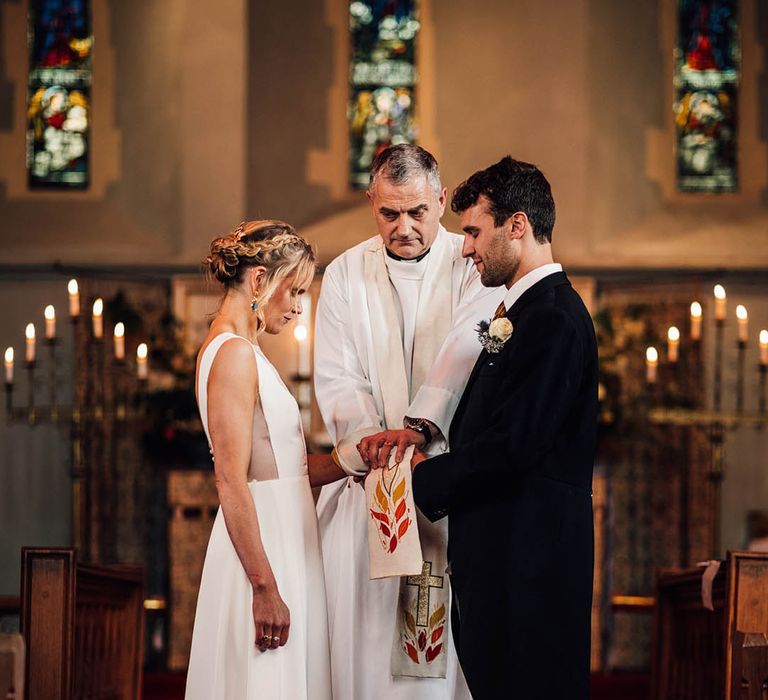 The bride and groom participate in their religious church wedding in Wales 