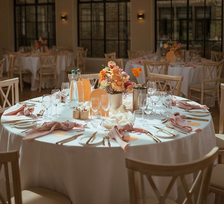 Stunning baby pink and orange wedding tablescape with hanging flower cloud installation