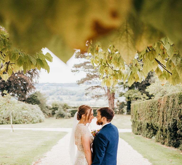 Real bride and groom stand together to pose for wedding portrait 