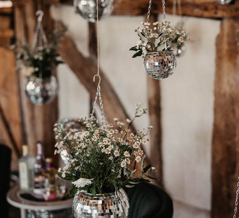 Hanging disco ball plant pot filled with daisies 