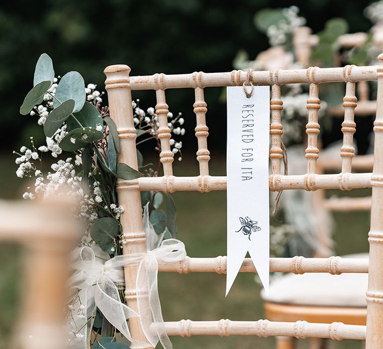 Reserved seat tag on the wedding chairs at the outdoor wedding ceremony at Langshott Manor