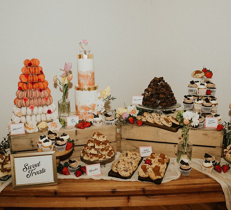 Yummy wedding dessert table filled with lots of sweet treats including macarons, cupcakes, flapjacks and cookies 