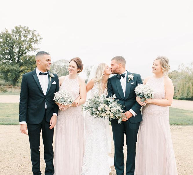 Wedding  party portrait with bridesmaids in pink dresses and groomsmen in tuxedos 