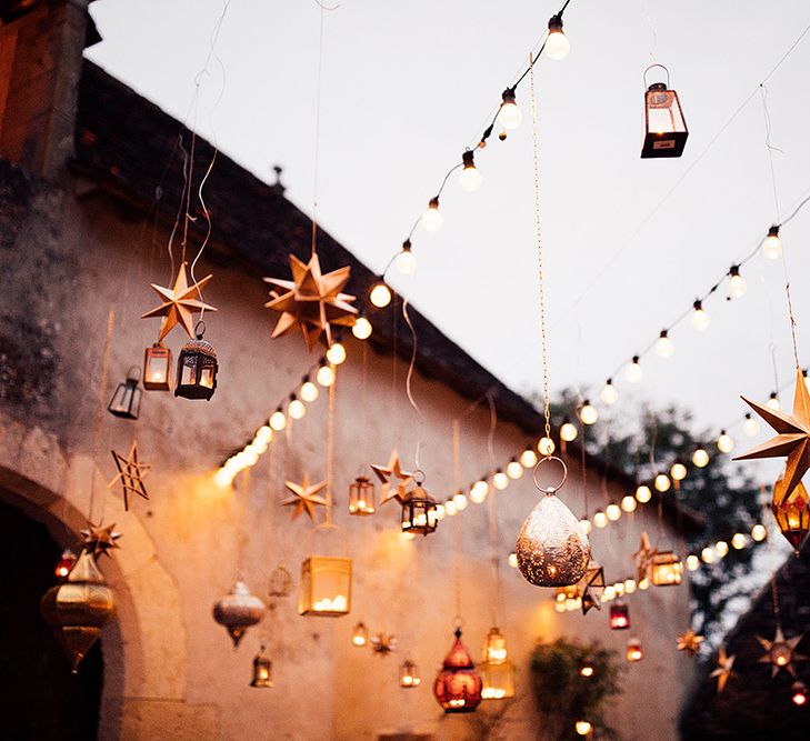 Hanging lanterns and festoon lighting at wedding with Moroccan themed wedding decor