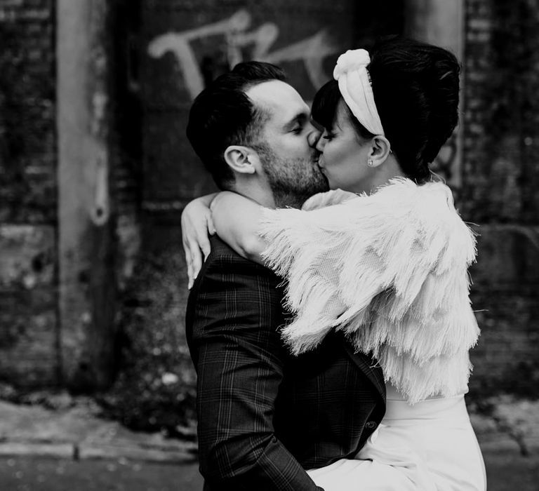 Groom lifting his bride and kissing her 