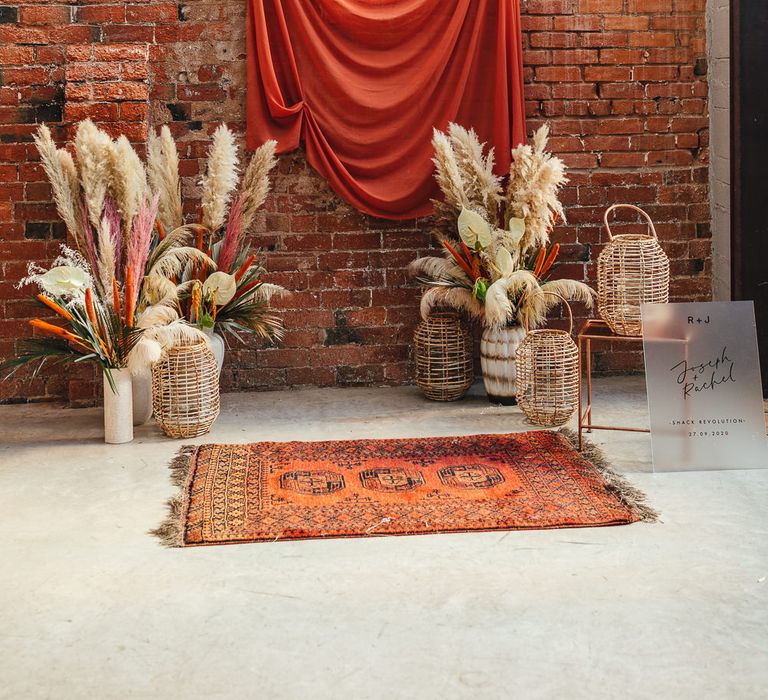 Dried flowers, wicker baskets, wool rug and fabric backdrop 