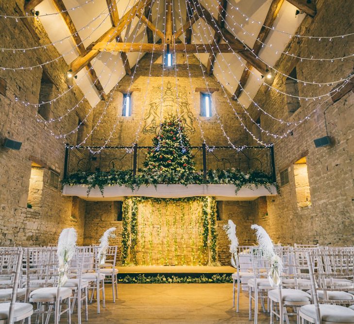 The Great Tythe Barn Christmas wedding with fairy lights and Christmas trees 