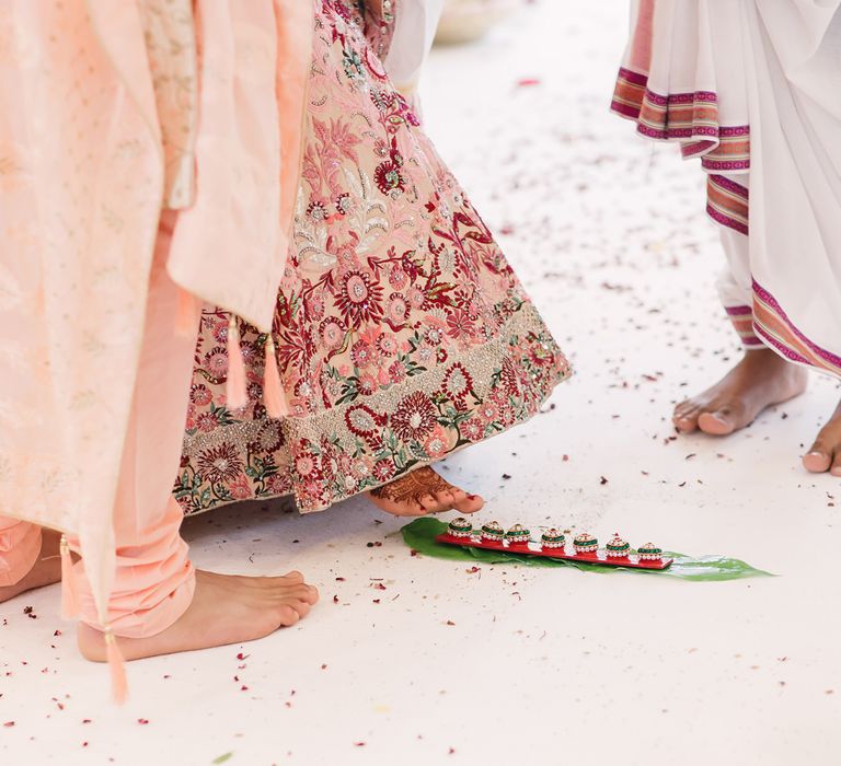 Bride standing on jewels during Hindu wedding ceremony 