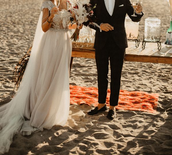 Bride and groom raise a toast at beach wedding in Crete