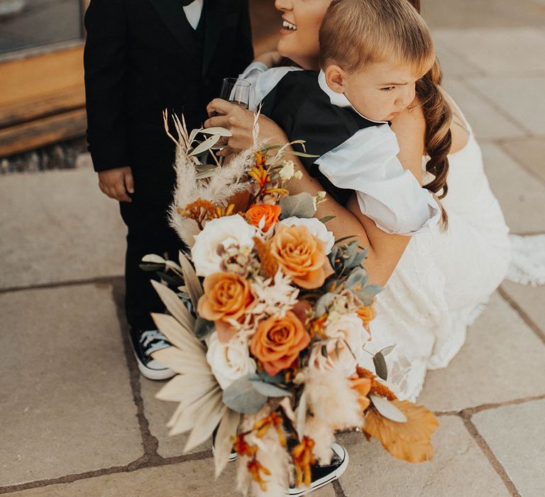 Bride kneels down to hug her children