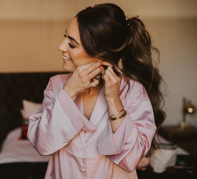 Bride puts in her earrings on wedding morning 