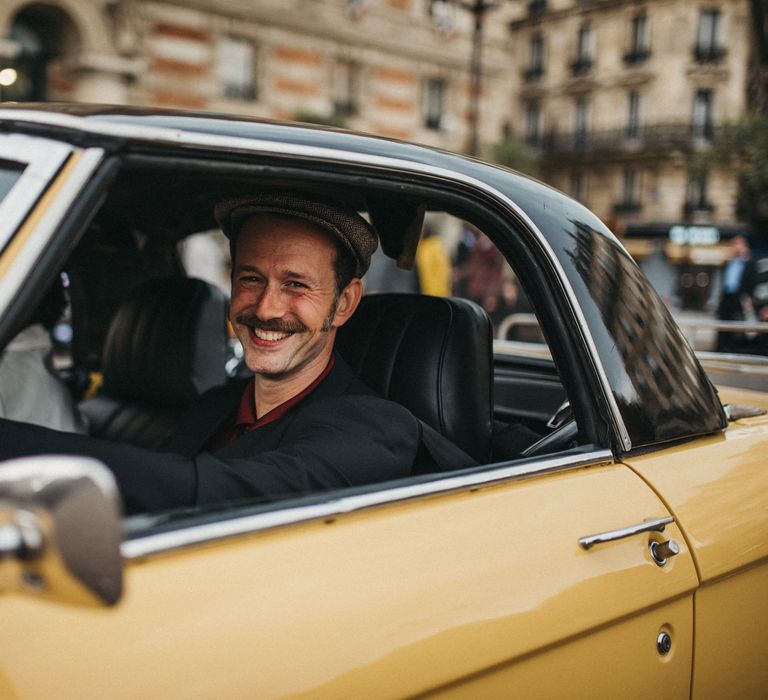 Groom in a yellow car with flat cap and moustache 