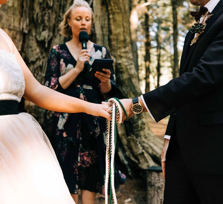 Handfasting wedding ceremony at outdoor forest wedding