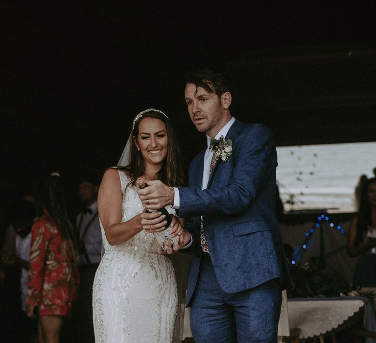 Bride & groom celebrate with champagne after wedding ceremony on the beach 