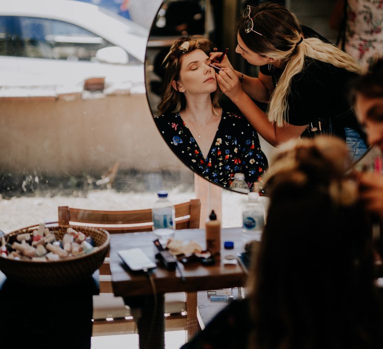 The bride having her makeup done on her wedding morning