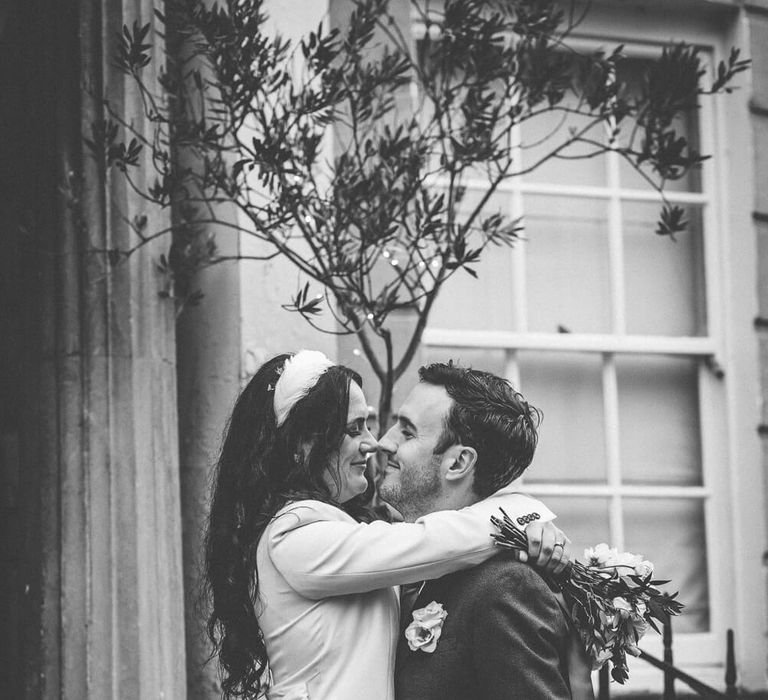 Bride and groom hugging, bride wears short wedding dress - black and white wedding photography