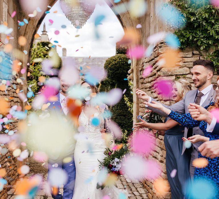 Bride & groom walk through confetti 