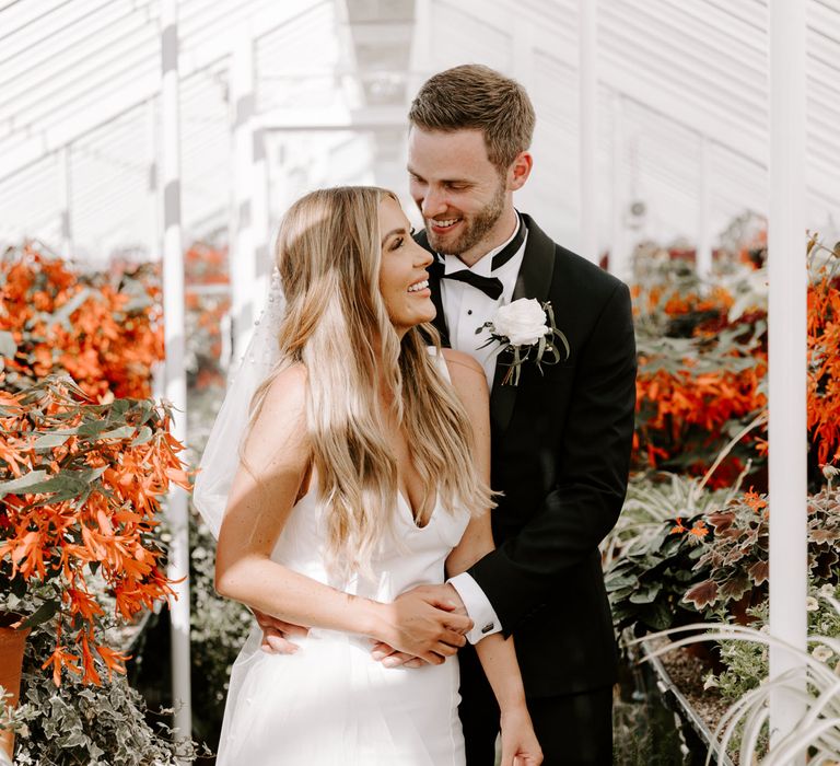 Groom wraps his arms around bride on her wedding day